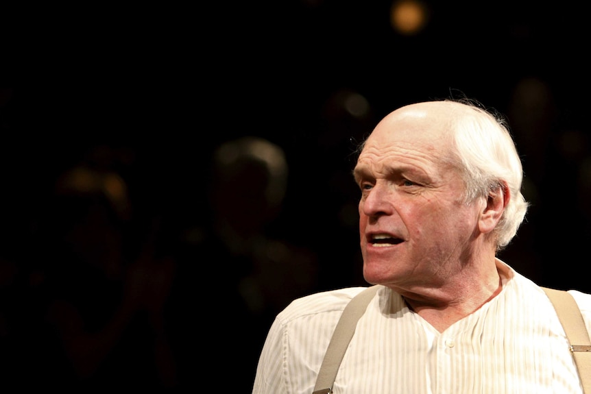 A balding Brian Dennehy is pictured close up wearing a stripped shirt and suspenders.
