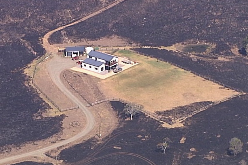 A house surrounded by burnt-out countryside