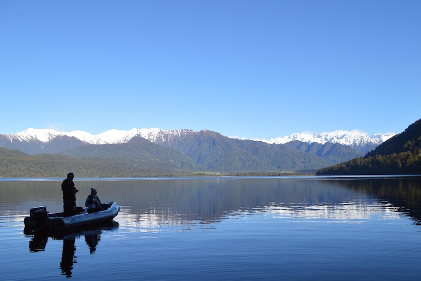 A boat floats out on a blue lake