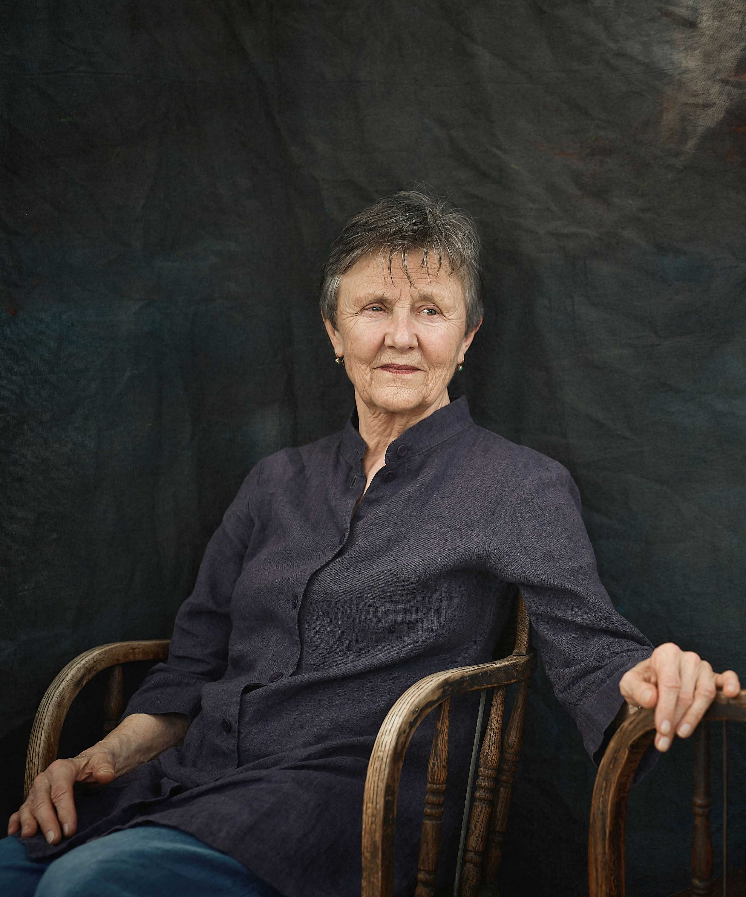 Author photo, Helen Garner seated in a wooden chair