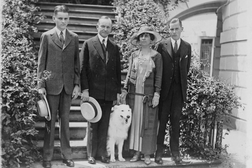 Calvin Coolidge, his wife Grace, their two sons and a dog stand on the steps at the White House for a photo.