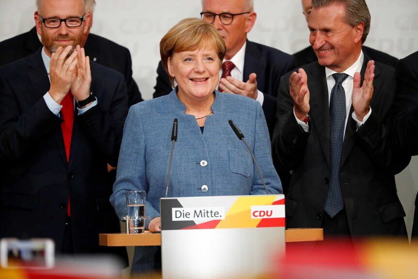 Christian Democratic Union (CDU) party leader and German Chancellor Angela Merkel react to exit polls.
