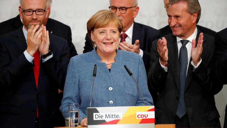 Christian Democratic Union (CDU) party leader and German Chancellor Angela Merkel react to exit polls.