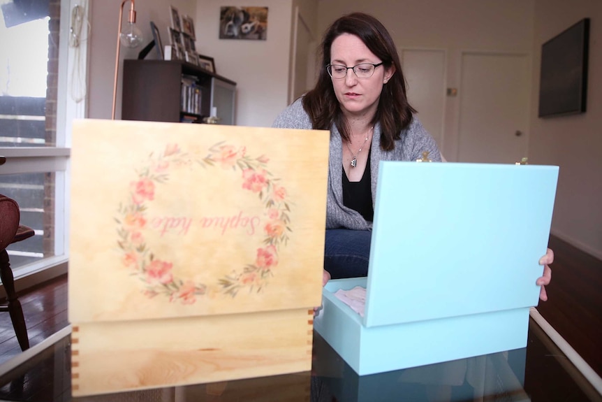 A mother looks at mementoes for her children who died in utero