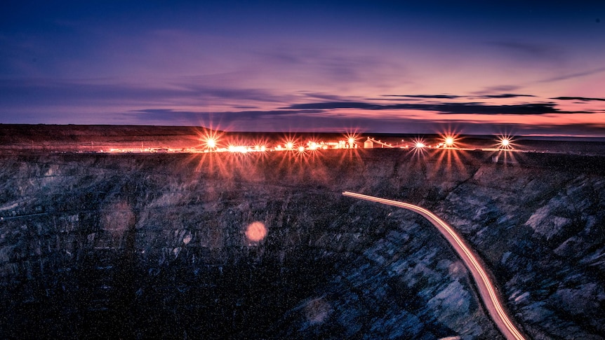 Open pit gold mine at sunset