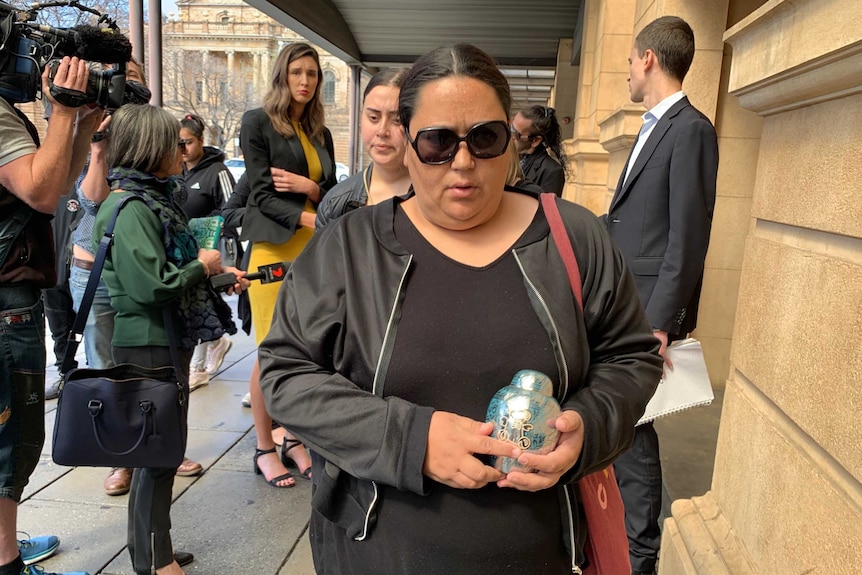 Zayne's mother Chantelle Young carrying the urn containing Zayne's ashes