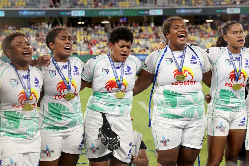 Fijiana Drua teammates link arms and sing during the Super W Final of 2023 in Townsville