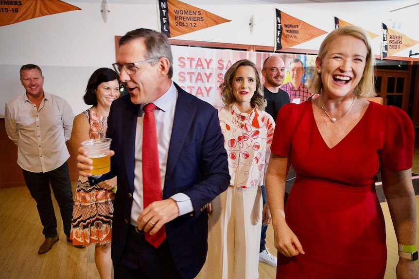 Michael Gunner, his deputy Nicole Manison and other members of his team smile and laugh after winning the election.