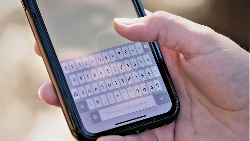 A close up of a phone keyboard in a language other than English.