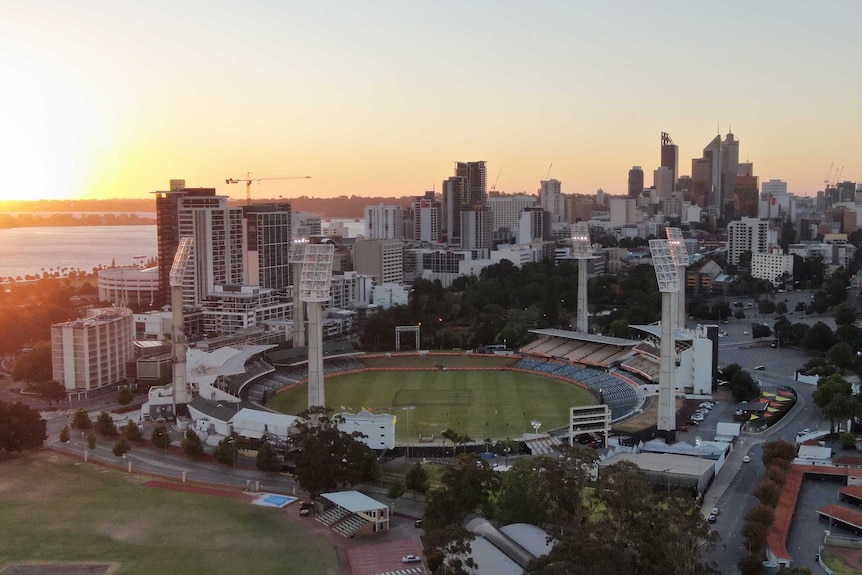An aerial view of the WACA Ground at sunset with the Perth CBD in the background.