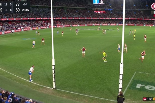 A wide shot of the ground from behind the goals at Docklands, with a Kangaroos player kicking out and Essendon playersdefending.