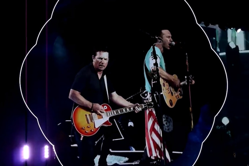 Michael J Fox plays guitar next to Coldplay's Chris Martin.