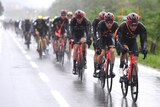 Team Ineos leads the peloton in the rain
