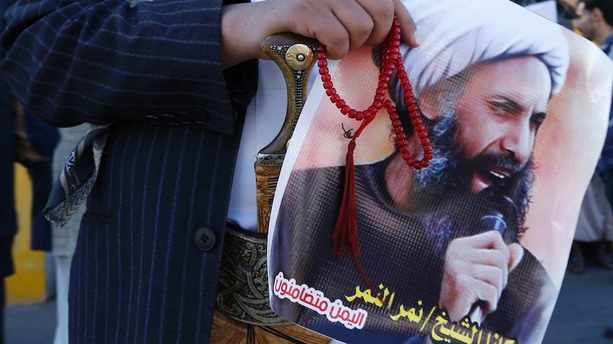 A Shiite protester carries a poster of Sheikh Nimr al-Nimr in 2014.