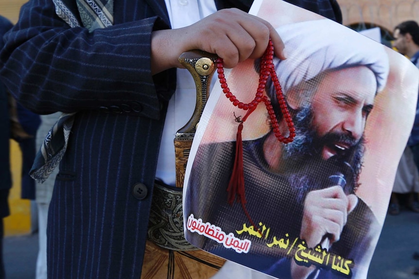 A Shiite protester carries a poster of Sheikh Nimr al-Nimr in 2014.