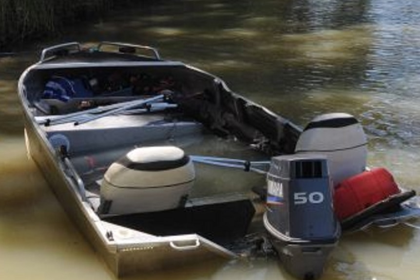 A small boat sitting low near the banks of a river