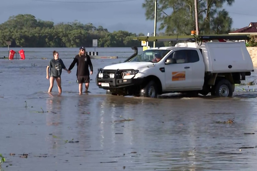 Two people walk in flood water