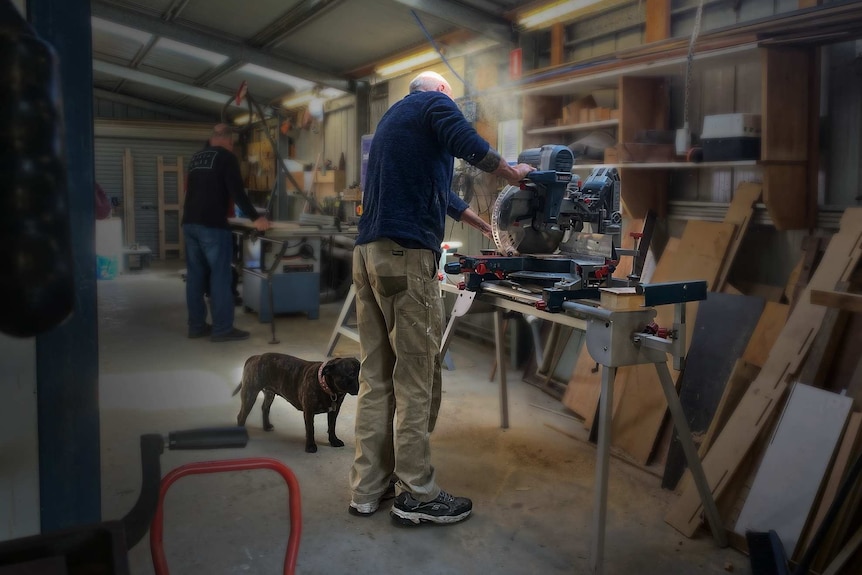 Tony Bull woodworking in a workshop.