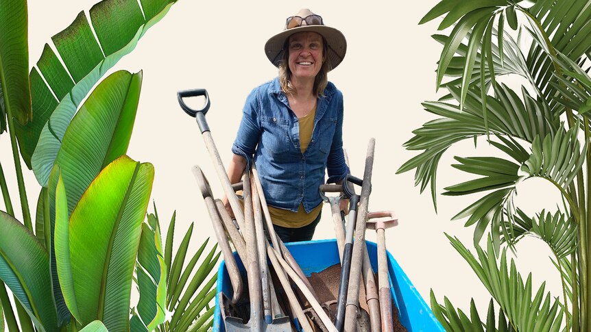 Gardening Australia presenter Millie Ross holds a wheelbarrow filled with garden tools like shovels, to make gardening easier.
