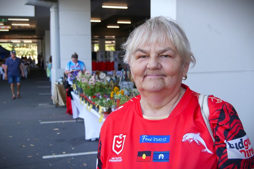 Woman in Redcliffe Dolphins NRL shirt.