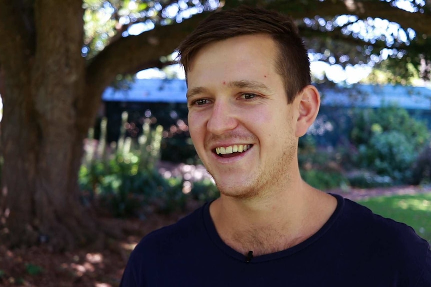 young man smiling in park