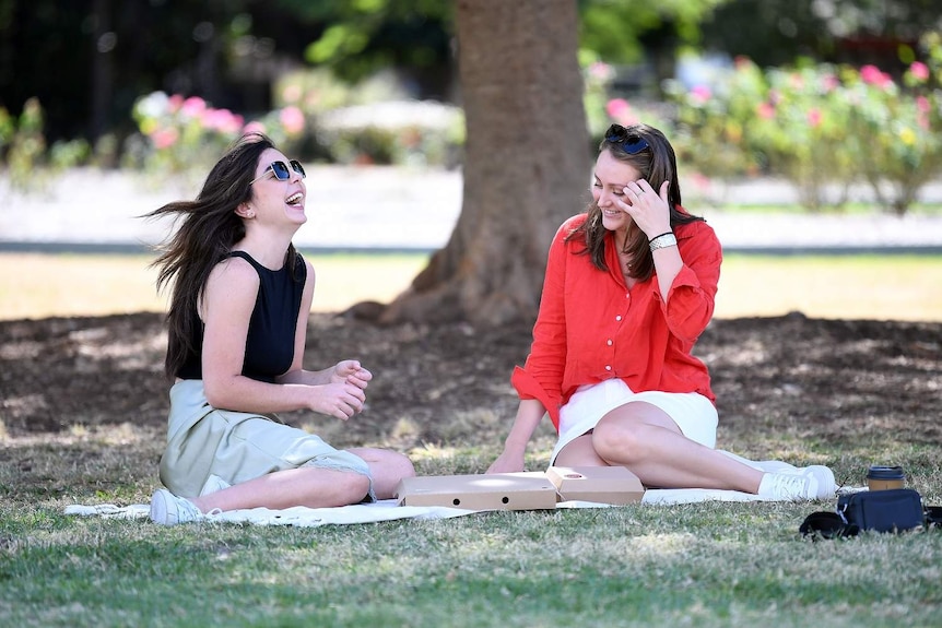 Mairead O'Callaghan (left) and her friend Emma enjoy a picnic lunch at New Farm Park in Brisbane.