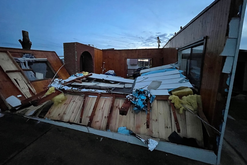 A collapsed living room wall on a house with no roof