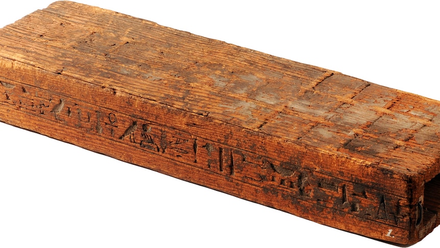 A wooden brick with etchings on it forms and ancient egyptian board game