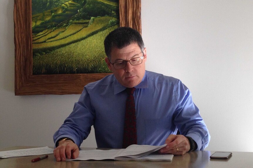 Ron Ben David reading a document at a desk.
