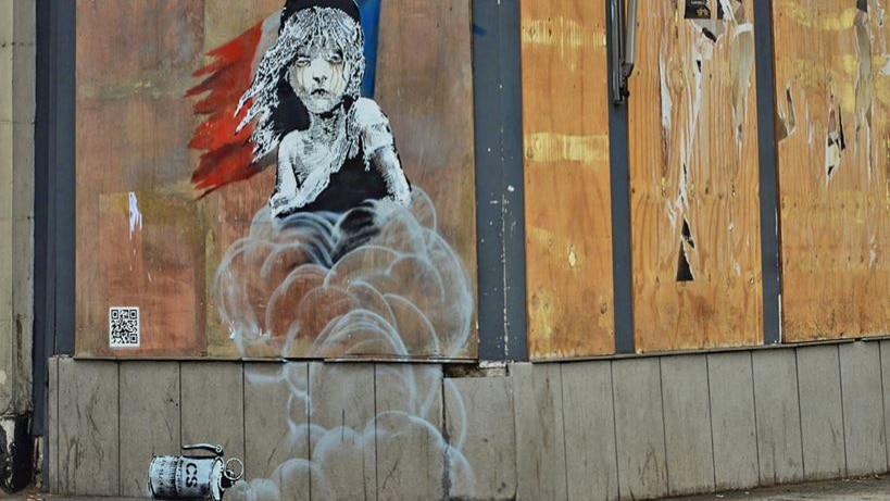 A mural by Banksy depicting "Les Miserables" character Cosette engulfed by clouds of gas.