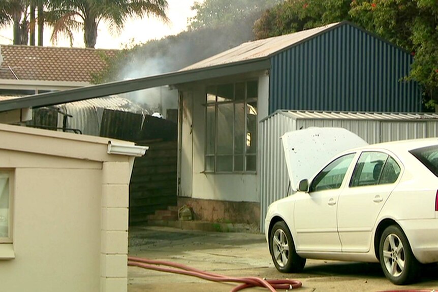 Smoke rises from a suburban shed.