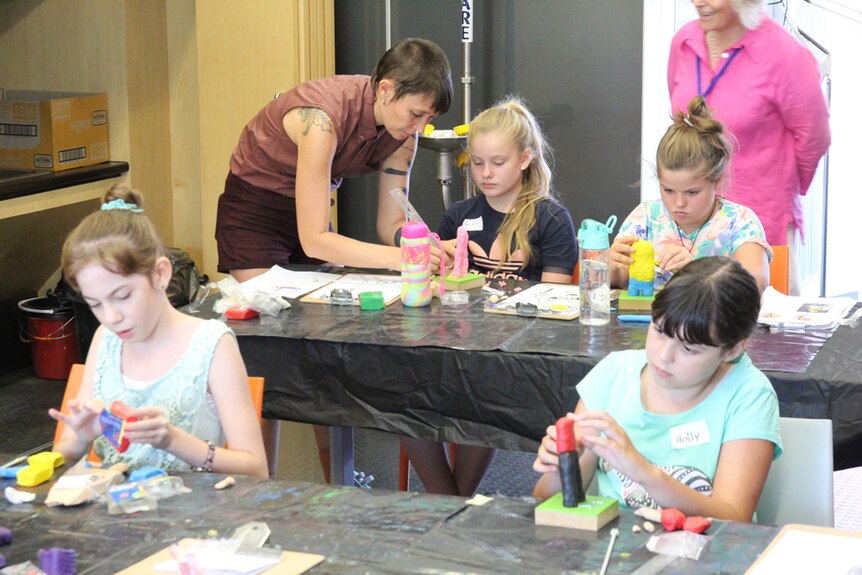 Sculptor Leonie Rhodes helps young students make superheroes art