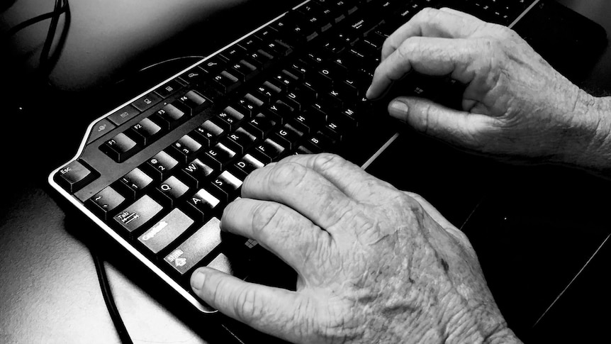 black and white photo of hands on a computer keyboard.