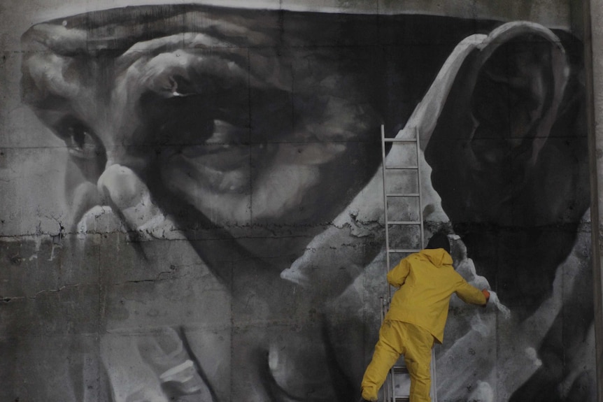 van Helton on a ladder spraypainting.