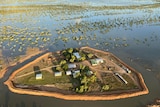 A flood levee surrounded by flood waters with buildings inside the levee 