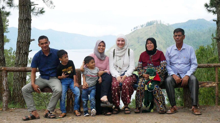 Foto keluarga dengan latar belakang pegunungan.
