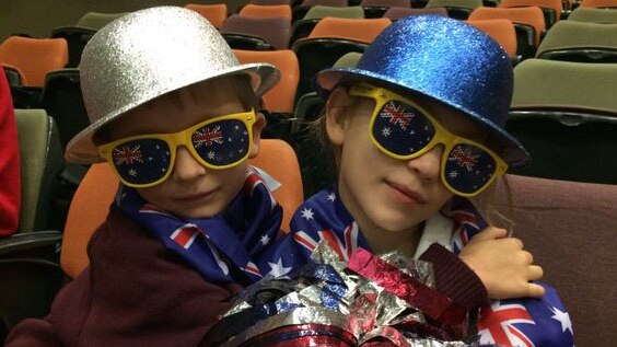 Two children wearing Australiana costumes celebrate Dami Im making the final of Eurovision