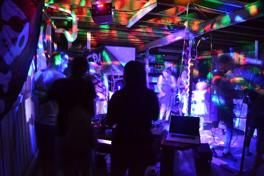 People dance under coloured lights at Julian Scharf's party