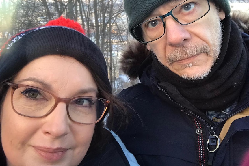 A woman and man in beanies in the snow. 