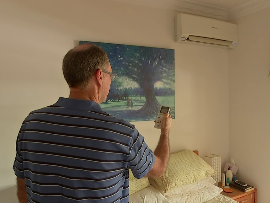 Peter Casey turns on one of his PeakSmart air conditioners.