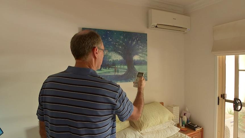 Peter Casey turns on one of his PeakSmart air conditioners.