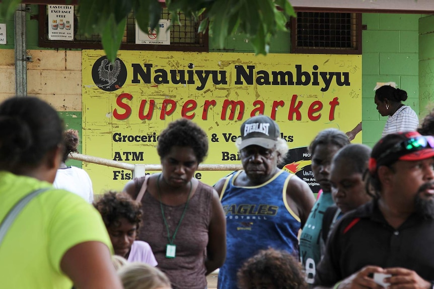 A group of locals standing in front of the community store.