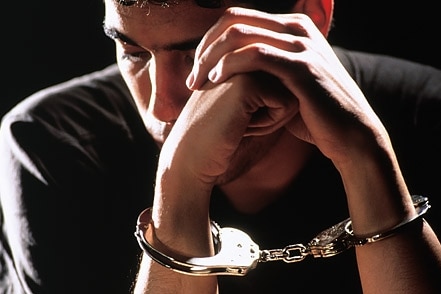 Male youth in handcuffs [Corbis: Robert Essel]
