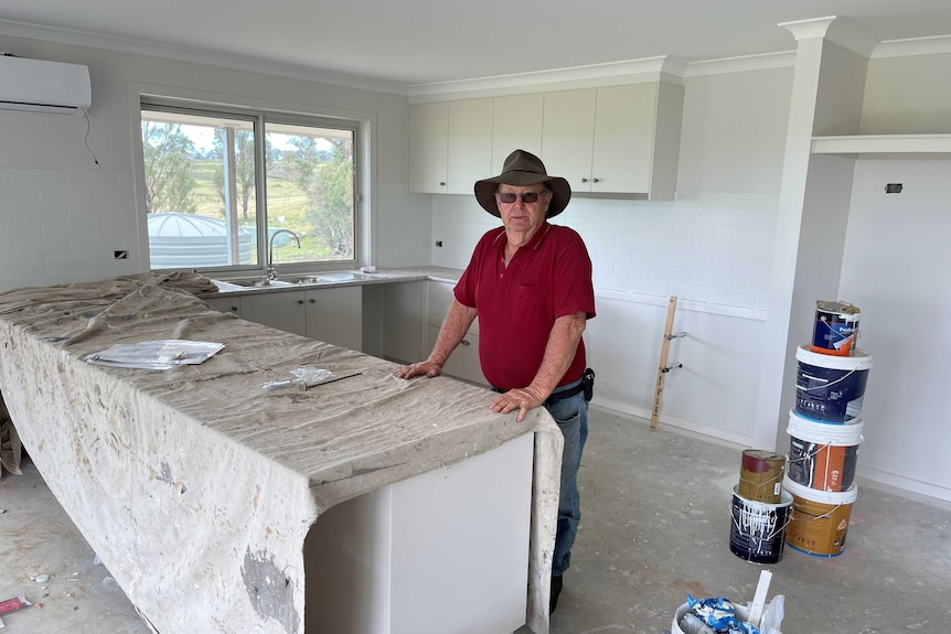 Older man standing in his mostly complete new home