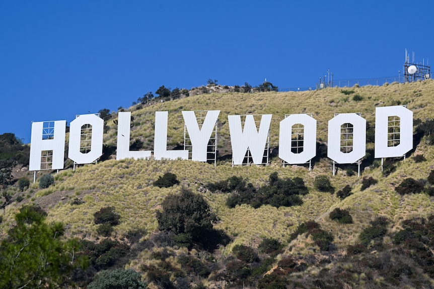 A view of the Hollywood sign in Los Angeles, California, from below, showing the full sign and its supporting bracing.