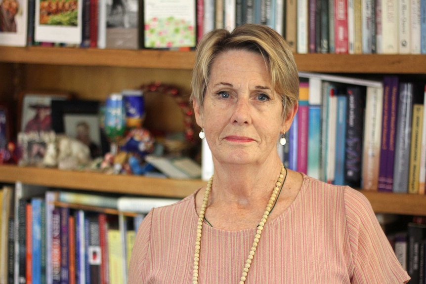 Psychologist Suzy Dormer stands in front of a bookshelf