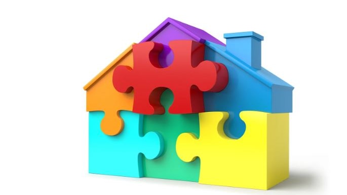 Imgae of a graphic of a house that is made of jigsaw puzzle pieces in bright colours 