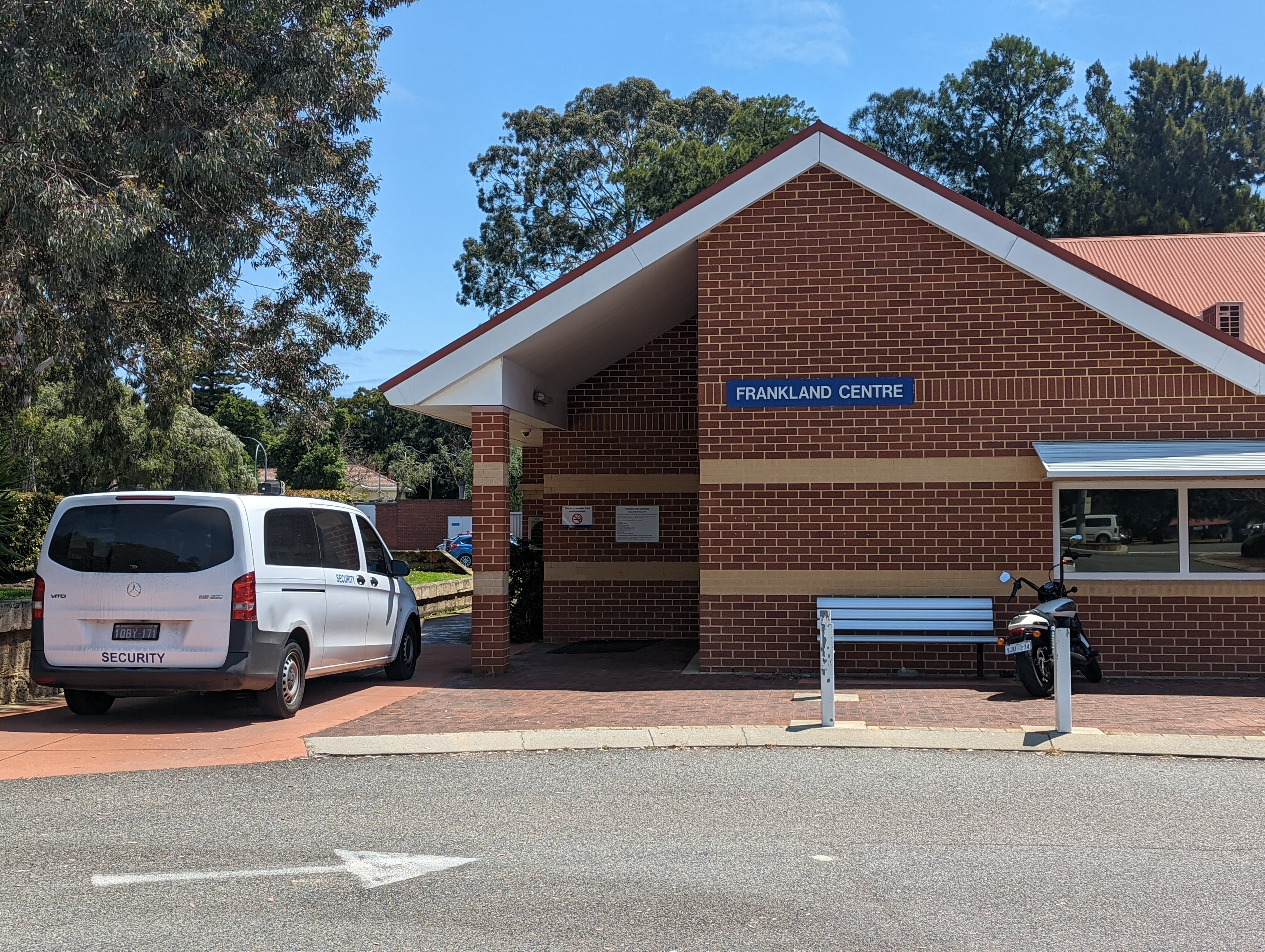 The brick exterior of the Frankland Center with a truck labeled "Guard" parked outside.