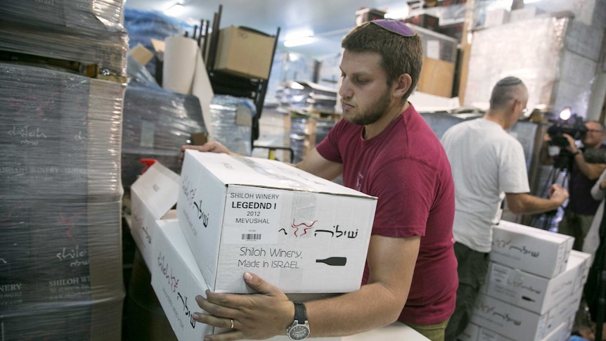 A worker carries boxes containing wine bottles for export at Shiloh Wineries.