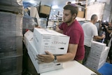 A worker carries boxes containing wine bottles for export at Shiloh Wineries.